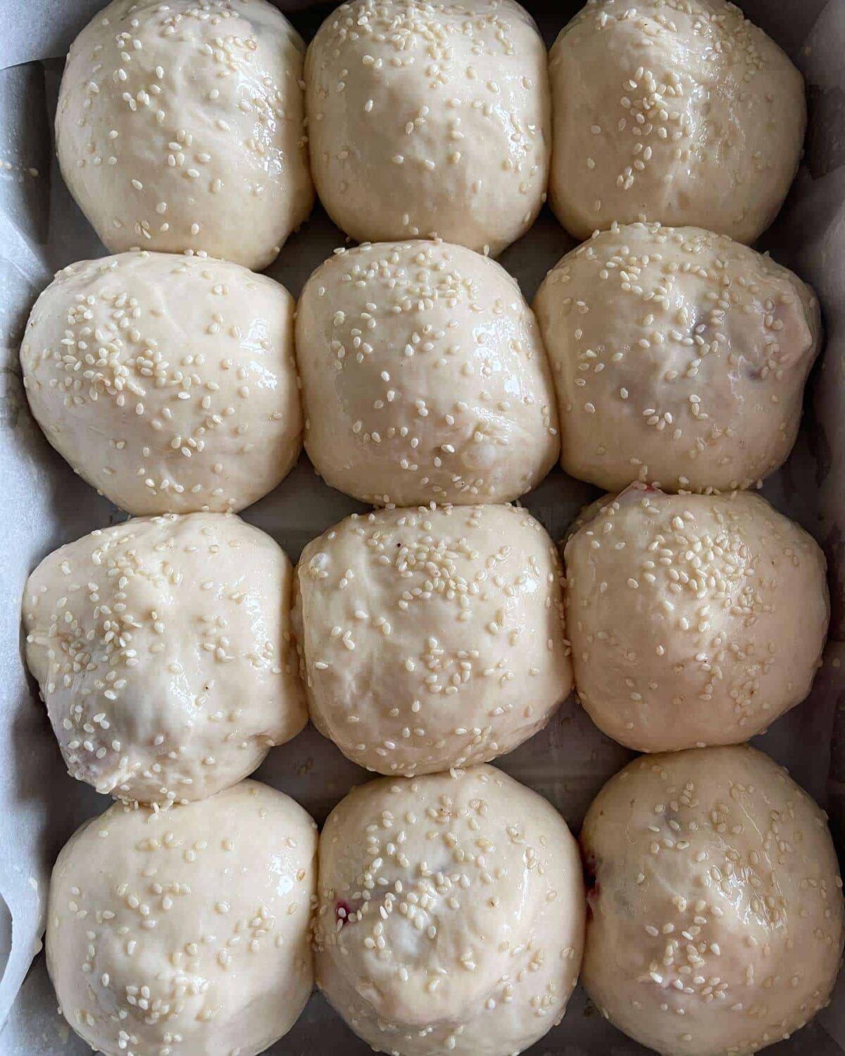 egg washed dough balls topped with sesame seeds