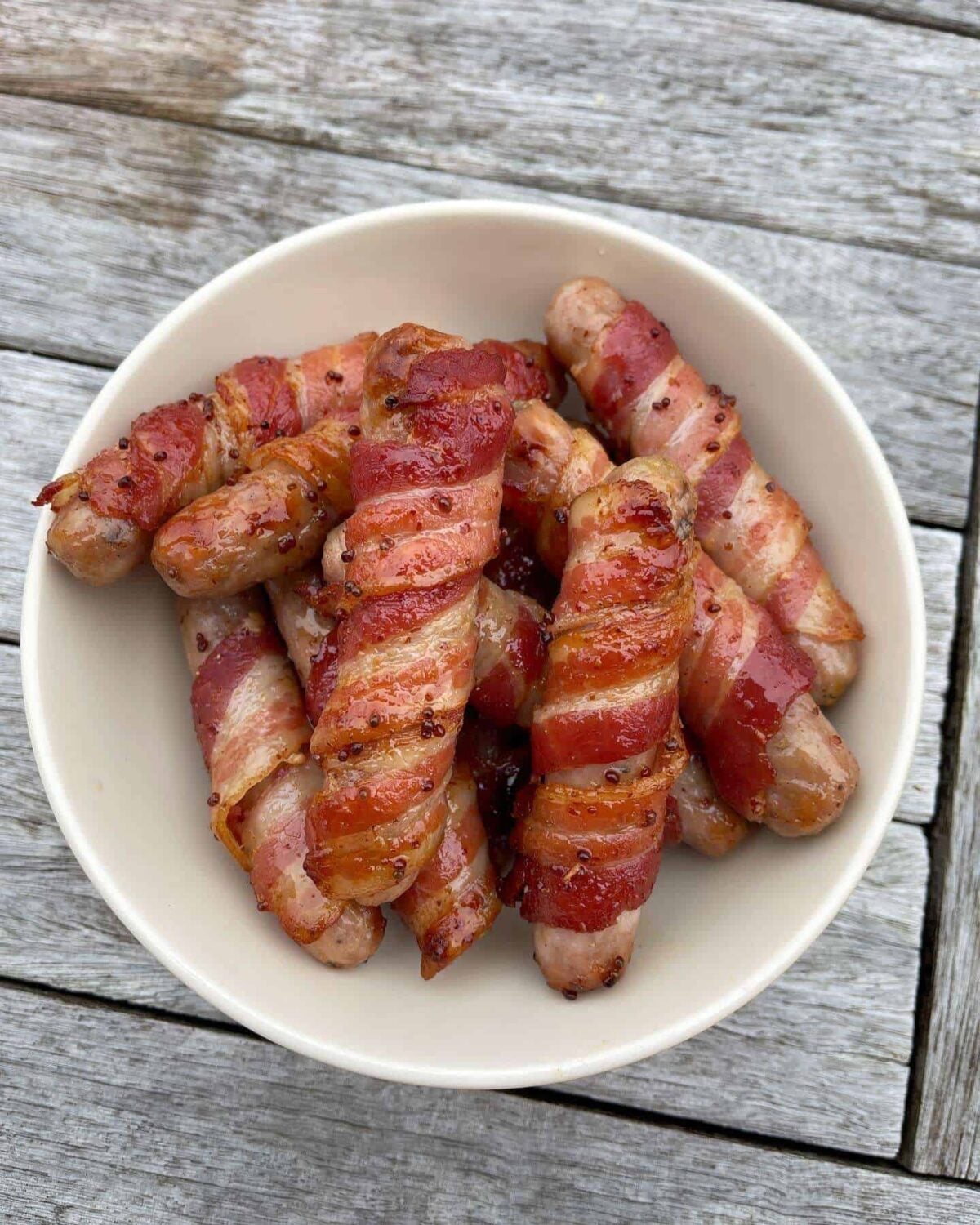 bowl of glazed pigs in blankets