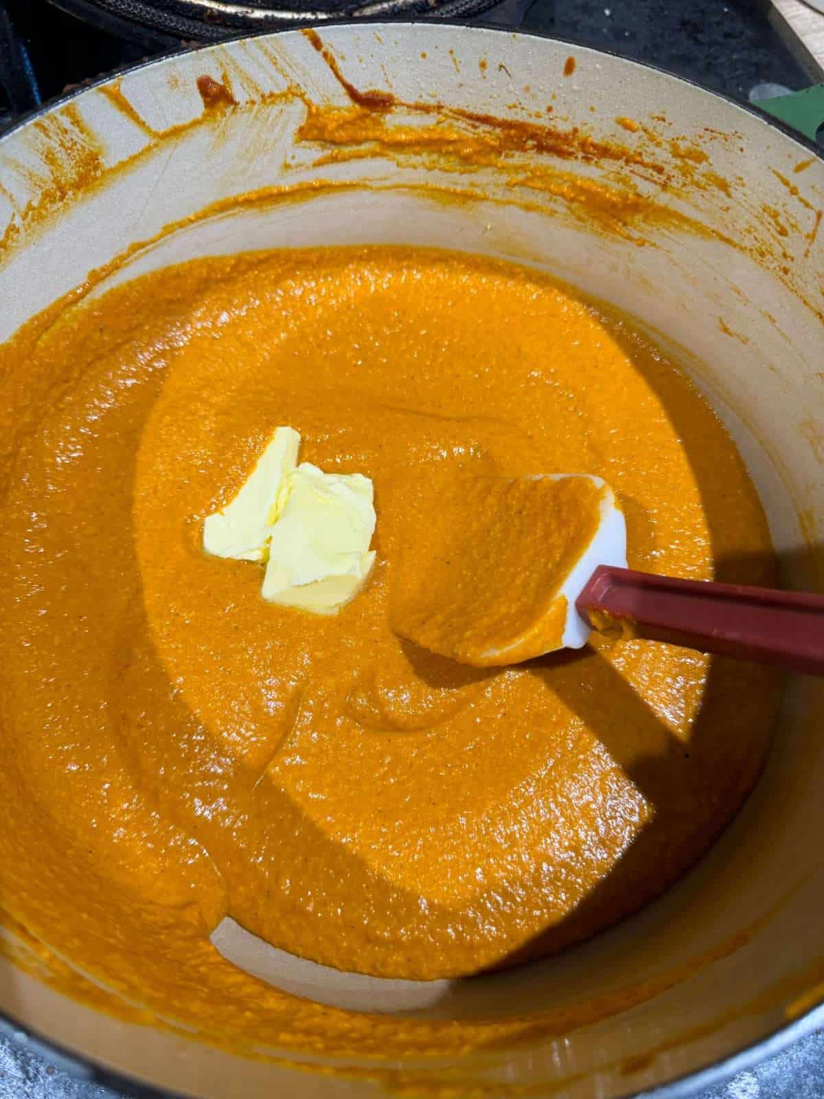 stirring butter in curry sauce