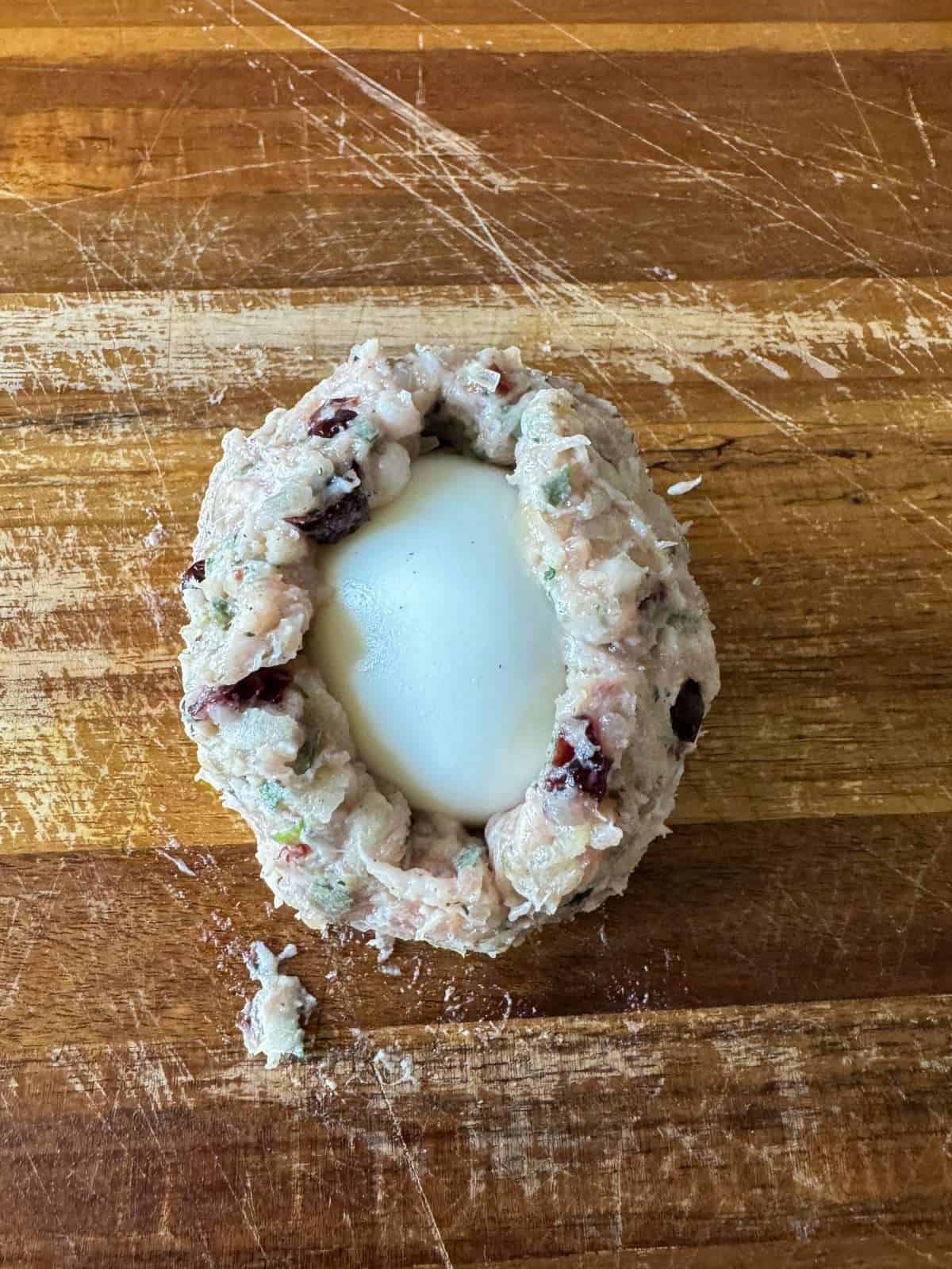 wrapping egg in sausage meat