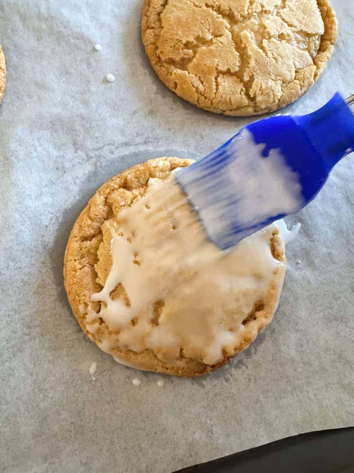 brushing lemon icing onto warm cookie