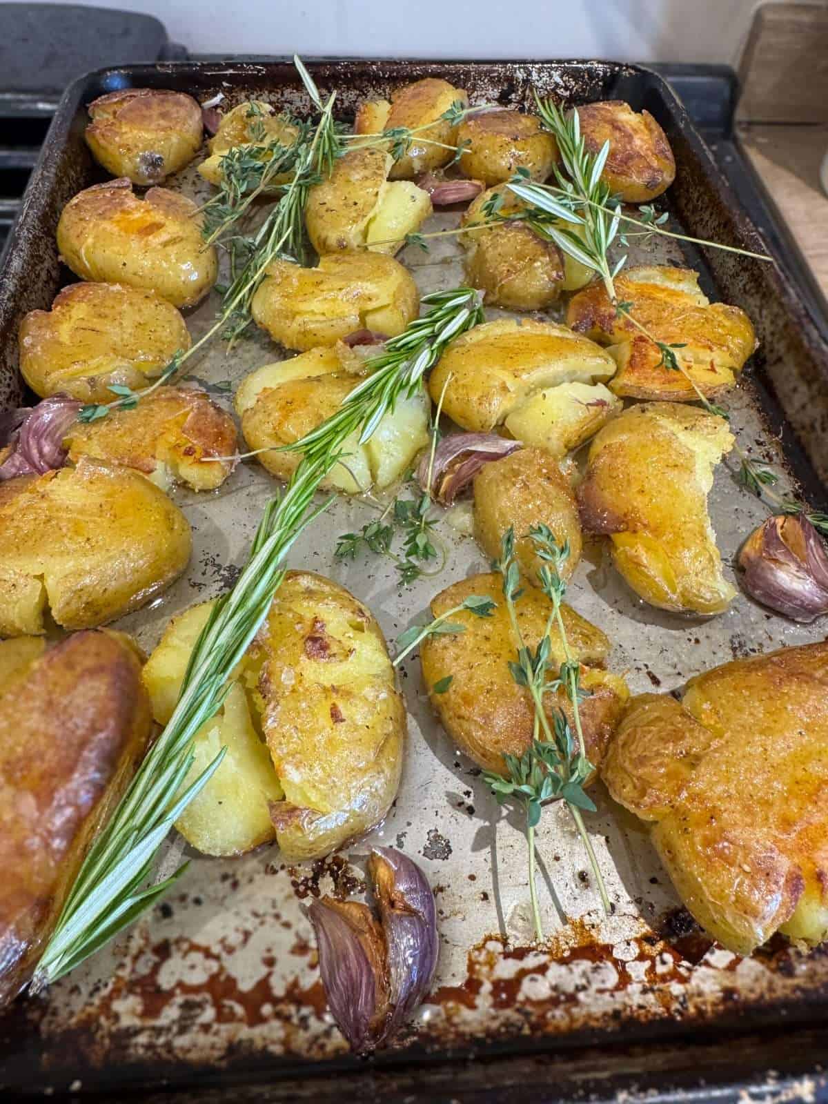 adding fresh herbs to roasted potatoes