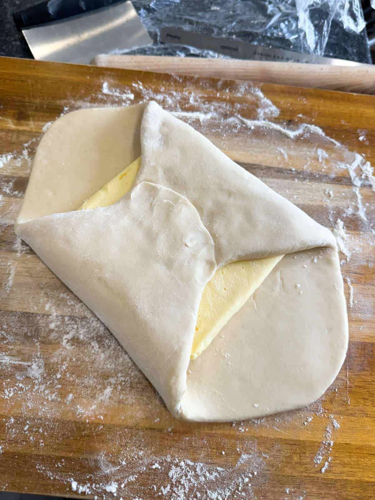 folding dough over butter to seal