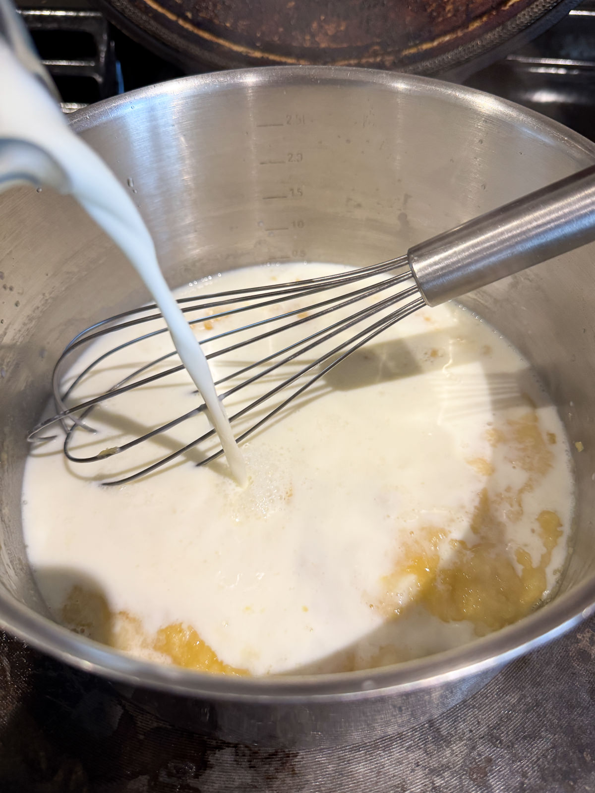 pouring milk into roux