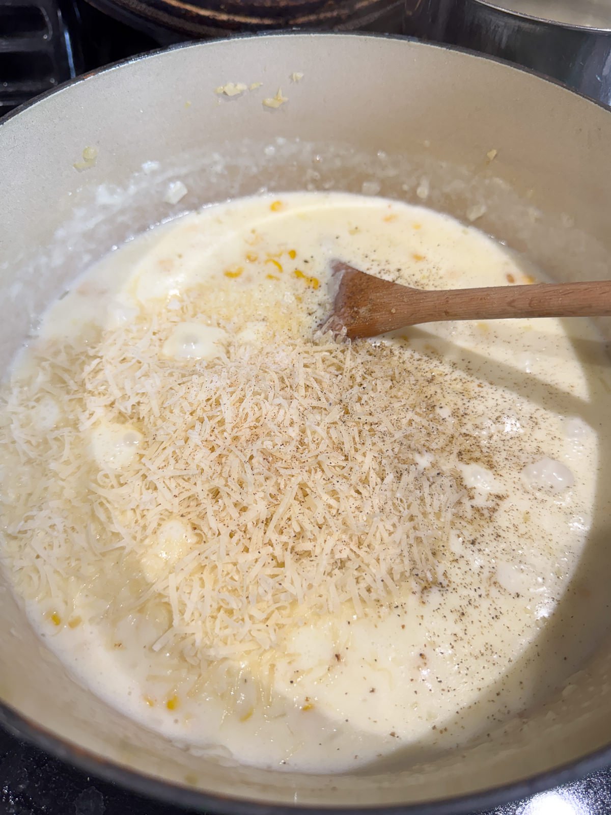 adding parmesan to creamed corn