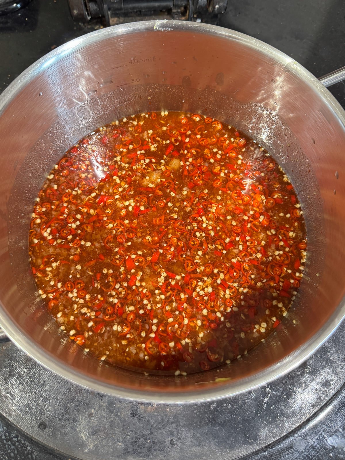 chopped chillies in pan with vinegar sugar