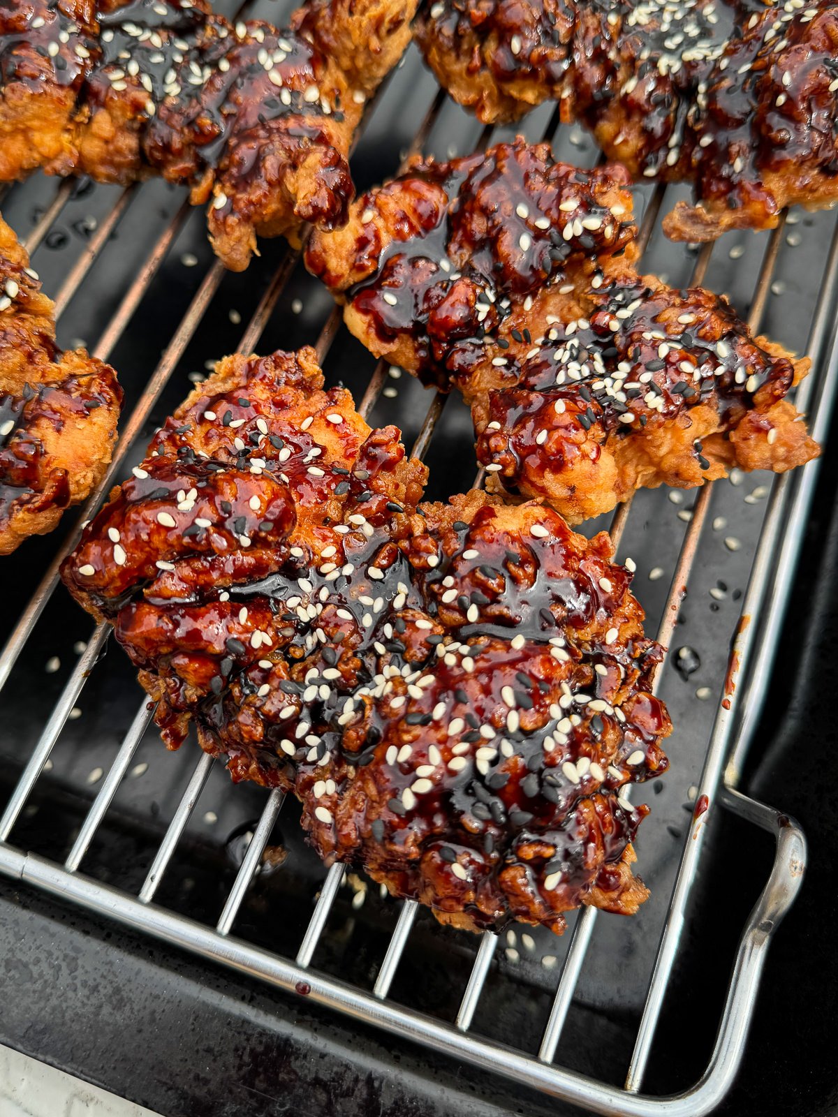 glazed Korean fried chicken thighs topped with sesame seeds