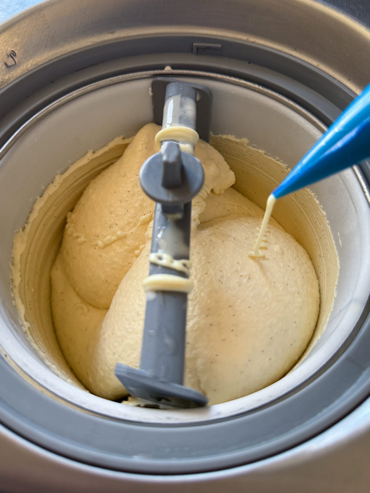 piping white chocolate into churning ice cream