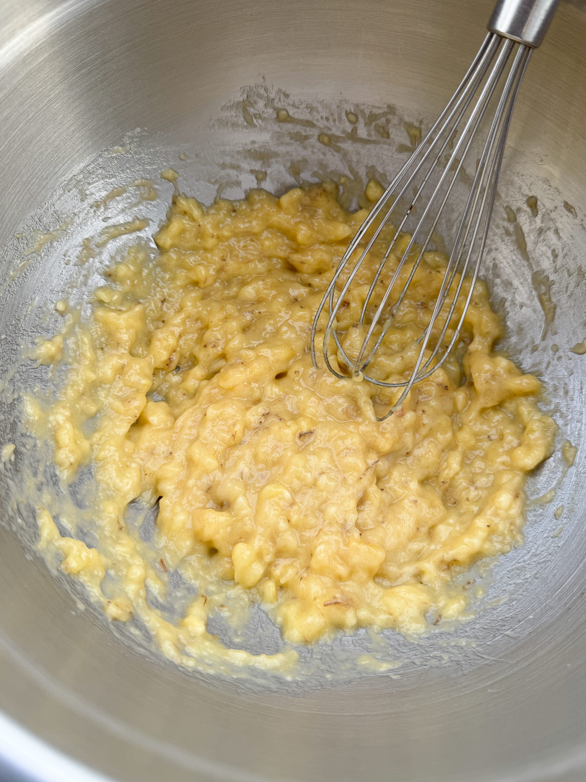 mashing ripe bananas with a whisk