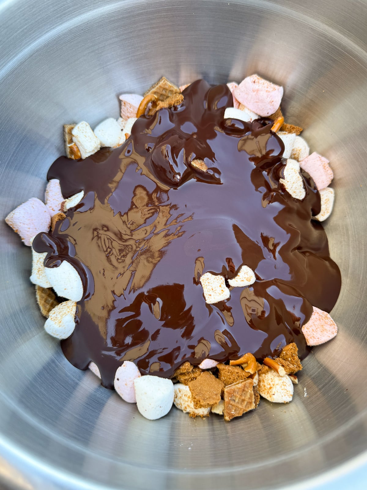 mixing rocky road with melted chocolate butter mix
