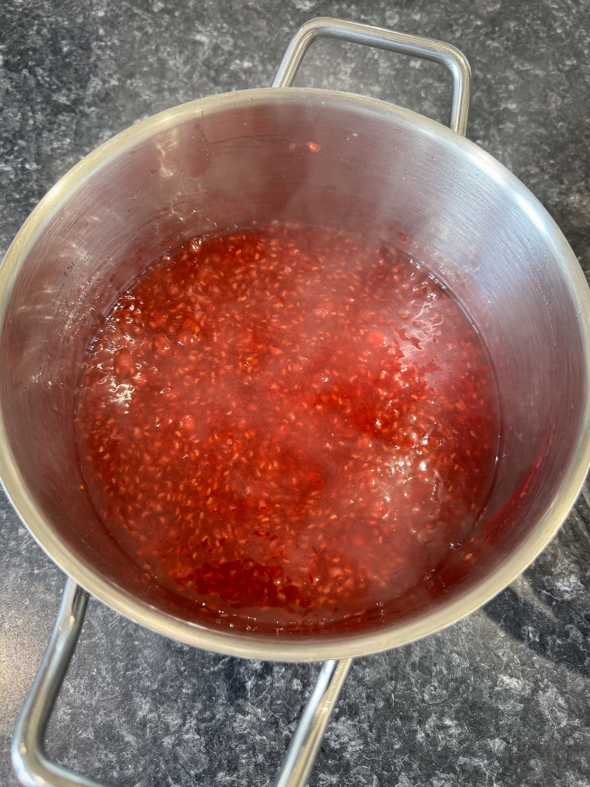 cooking raspberries into coulis on stove