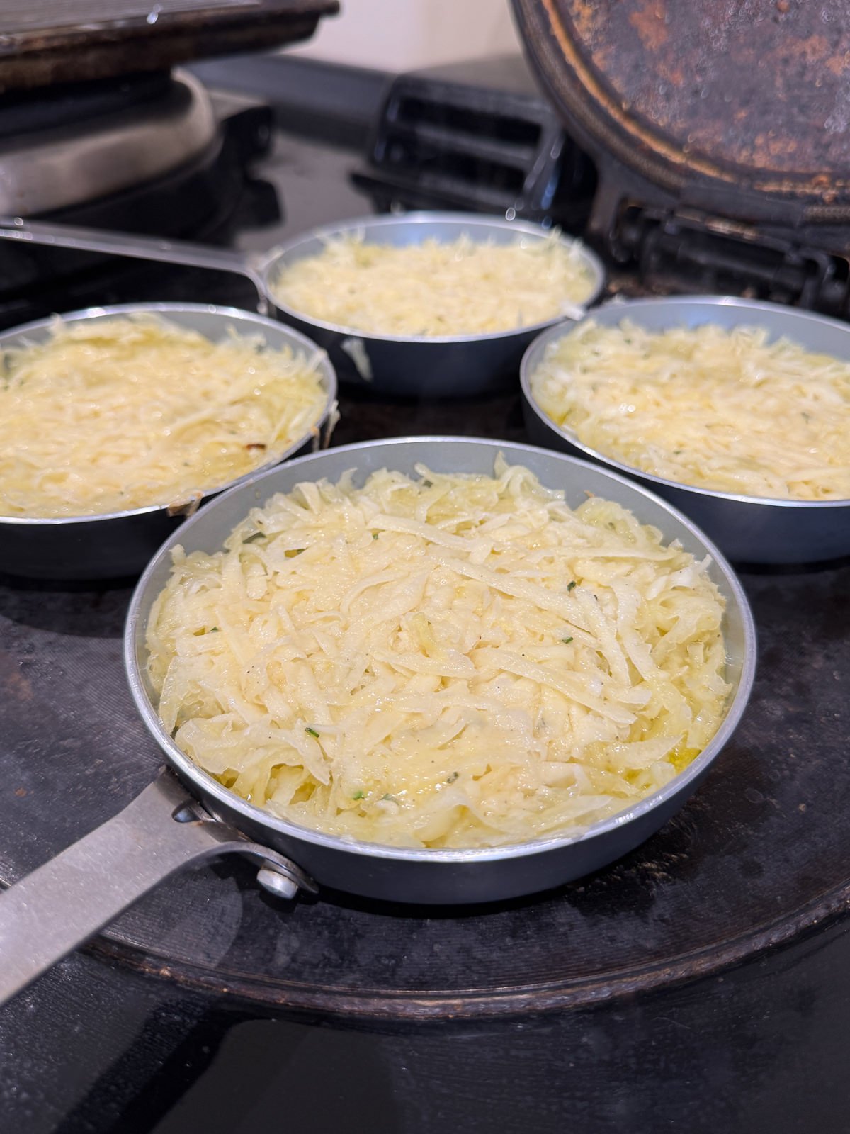 rosti mix pressed into frying pan for even layer