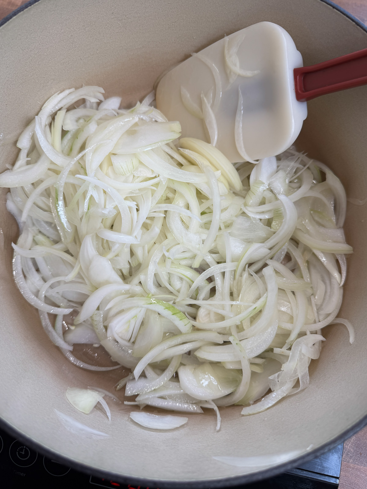 thinly sliced onions in pan for caramelising